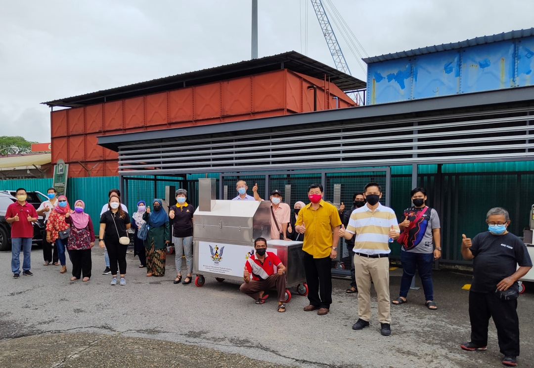 (From second right, front) Tiang, Tiong, Ting (sixth right, front), Nazatusyima (eighth right, front) and other councillors and SMC staff pose with hawkers during the handover of the new barbeque kiosks. u00e2u20acu2022 Borneo Post