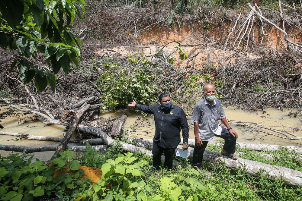 Ulu Kinta assemblyman Muhamad Arafat Varisai Mahamad points at a river that has been affected by kaolin mining in Kampung Kolam, Tanjung Rambutan September 30, 2021. u00e2u20acu2022 Picture by Farhan Najib
