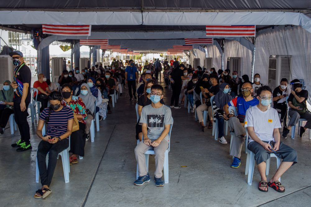 People queue as they wait to receive their Covid-19 jab at the Axiata Arena in Bukit Jalil September 23, 2021. u00e2u20acu201d Picture by Shafwan Zaidon