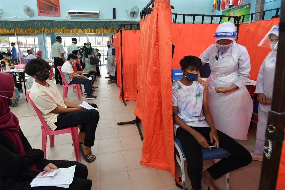 A health officer administers the Pfizer-BioNTech Covid-19 vaccine to a student at Sekolah Menengah Kebangsaan Sultan Sulaiman in Kuala Terengganu, September 21, 2021. u00e2u20acu201d Bernama pic 