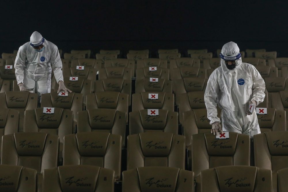 Workers in protective suits mark seats for social distancing at a movie theatre ahead of its reopening at TGV Cinemas in Central I-City, Shah Alam September 14, 2021. u00e2u20acu201d Yusof Mat Isa