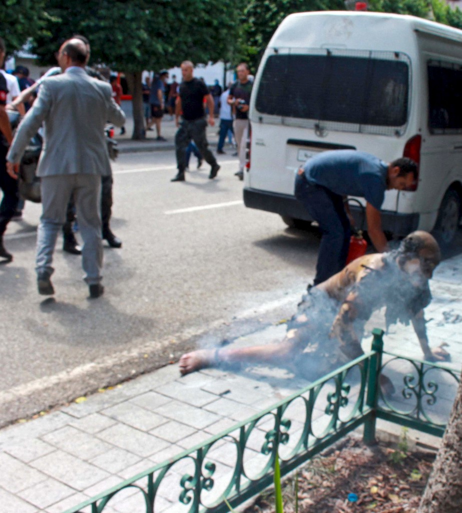 A man, who set himself on fire, is helped by a passerby in the Habib Bourguiba avenue in the capital Tunis on September 11, 2021, before being taken to hospital for treatment. u00e2u20acu201d AFP pic