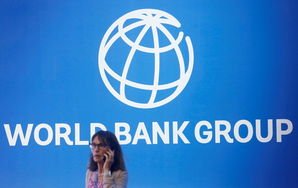 A participant stands near a logo of World Bank at the International Monetary Fund-World Bank Annual Meeting 2018 in Nusa Dua, Bali October 12, 2018. u00e2u20acu201d Reuters picnn