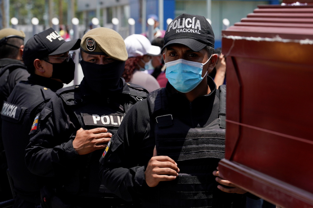 Police officers stand guard next to a coffin outside a morgue after a deadly riot broke out at the Penitenciaria del Litoral prison in Guayaquil, Ecuador September 30, 2021. u00e2u20acu201d Reuters pic