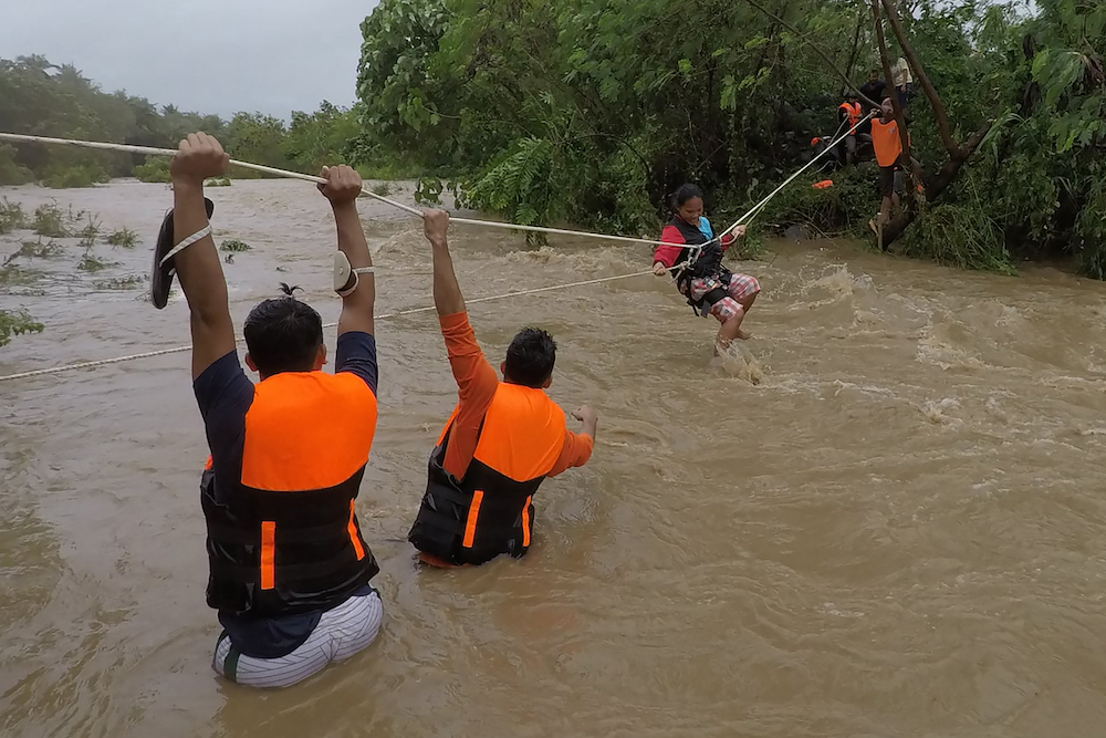 Rescuers evacuate residents from their homes near a swollen river due to heavy rains brought about by Tropical Storm Kompasu in Gonzaga town. u00e2u20acu201d Gonzaga Municipal Disaster Risk Reduction and Management Office (Gonzaga-MDRRMO) handout via AFP