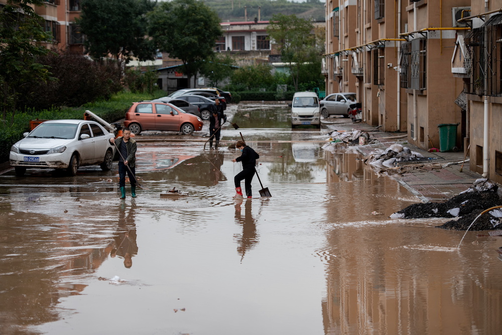 Villagers clear floodwaters near residential houses following heavy rainfall in Yitang county, Jiexiu city, Shanxi province, China October 10, 2021. u00e2u20acu201d cnsphoto via Reuters
