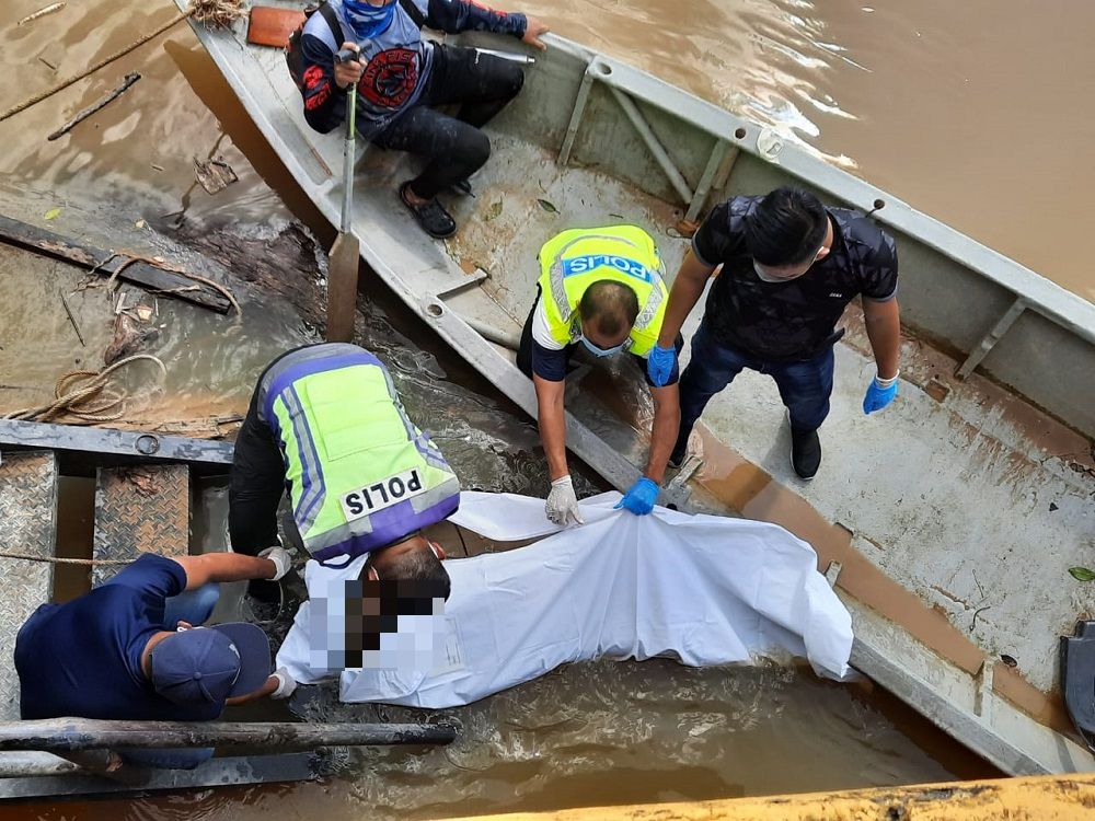 Policemen at the jetty preparing to transport the body to the hospital. u00e2u20acu201d Borneo Post Online pic