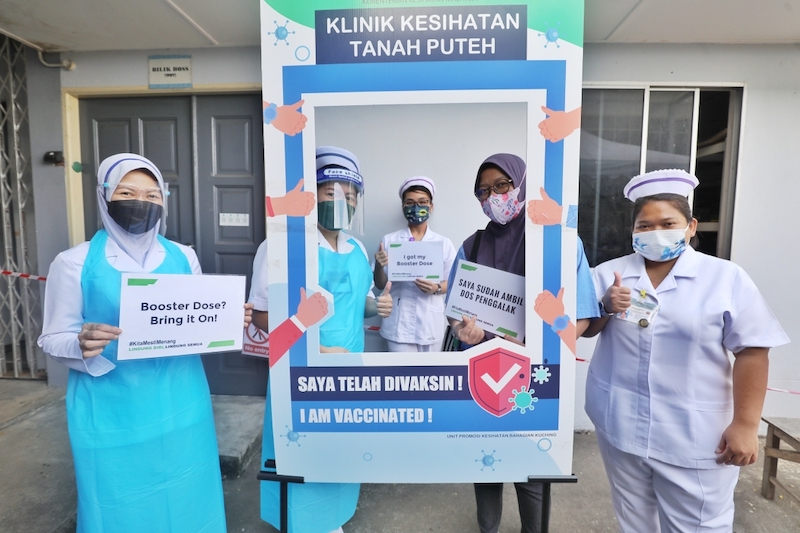 A medical frontliner (second right) posing with Tanah Puteh health clinic personnel after receiving her booster jab of Pfizer-BioNTech vaccine. u00e2u20acu201c Photos by Chimon Upon/Borneo Post Online
