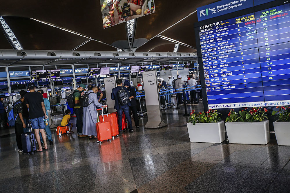 Travellers are seen with their luggage at the Kuala Lumpur International Airport after the government gave permission for fully-vaccinated Malaysians to travel abroad October 17, 2021. u00e2u20acu2022 Picture by Hari Anggara
