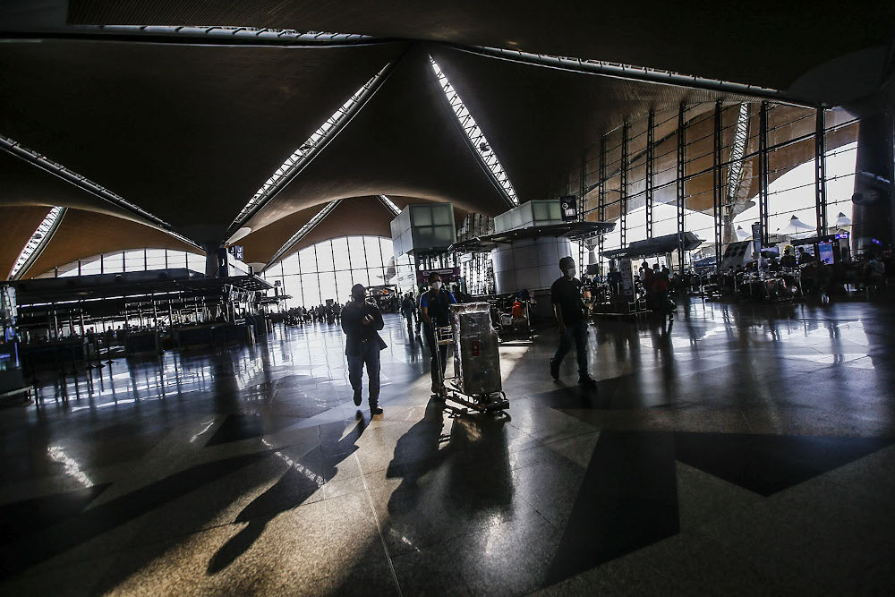 Travellers are seen with their luggage at the Kuala Lumpur International Airport after the government gave permission for fully-vaccinated Malaysians to travel abroad October 17, 2021. u00e2u20acu2022 Picture by Hari Anggara