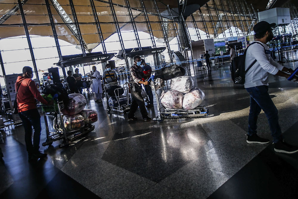 Travellers are seen with their luggage at the Kuala Lumpur International Airport after the government gave permission for fully-vaccinated Malaysians to travel abroad October 17, 2021. u00e2u20acu2022 Picture by Hari Anggara