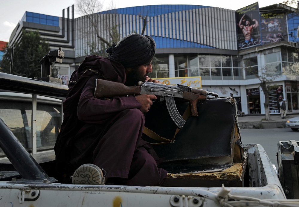 A Taliban fighter sits guard on a vehicle while his comrades are praying at Deh Bori square in Kabul, Afghanistan October 18, 2021. u00e2u20acu2022 Reuters pic