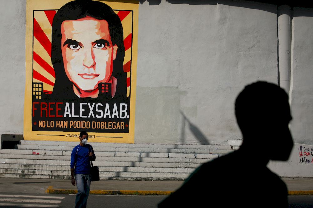People walk past graffiti in favour of the release of Colombian businessman Alex Saab, amidst the Coronavirus pandemic, on the west side of the city in Caracas, Venezuela on September 8, 2021. u00e2u20acu201d Photo by Javier Campos via Reuters