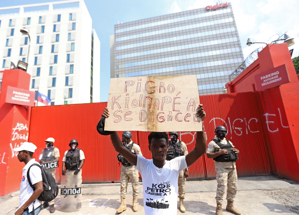 A protester holds a sign reading u00e2u20acu02dcThe biggest kidnapper is Digicelu00e2u20acu2122 as Haitians mount a nationwide strike to protest a growing wave of kidnappings in Port-au-Prince, Haiti October 18, 2021. u00e2u20acu2022 Reuters pic