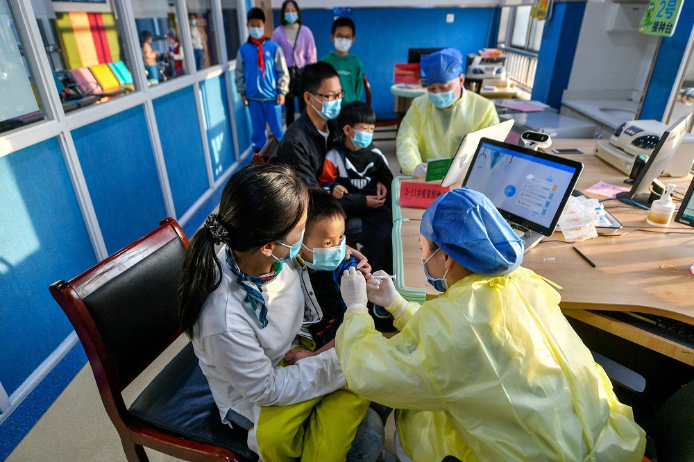 A medical worker administers a dose of Covid-19 vaccine to a child in Huzhou, Zhejiang province, China October 26, 2021. u00e2u20acu2022 China Daily via Reuters