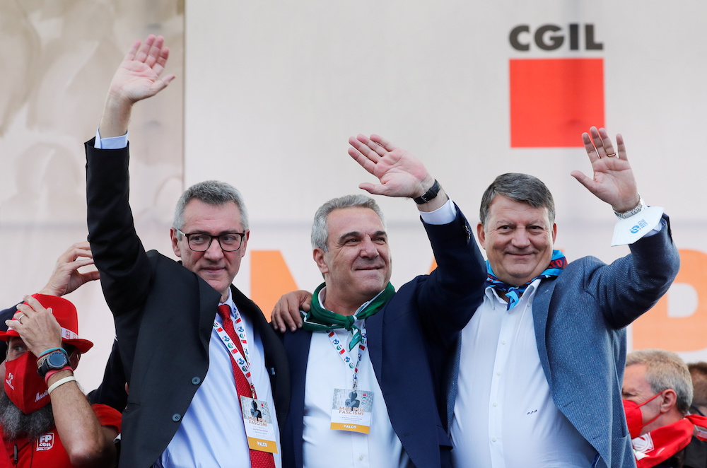 Union leaders Maurizio Landini, Luigi Sbarra and Pierpaolo Bombardieri wave during a protest against fascism a week after anti-vaccine riots by protesters including members of the far-right party Forza Nuova, in Rome, Italy, October 16, 2021. 
