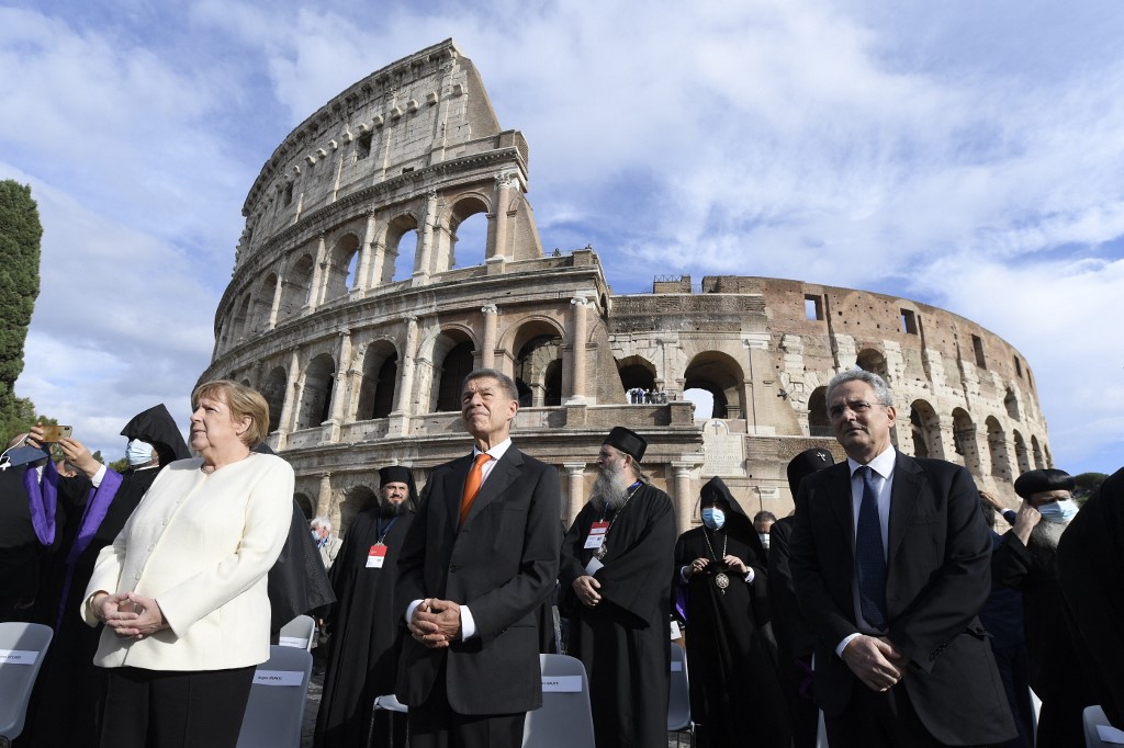 This photo taken on October 7, 2021 by the Vatican media shows German chancellor Angela Merkel (left) and her husband Joachim Sauer (second left) attending a Prayer and Meeting for Peace, by the Colosseum monument in Rome. u00e2u20acu201d Vatican Media / AFP pic