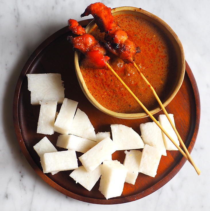 Dip the skewers and 'ketupat' in the thick peanut sauce.