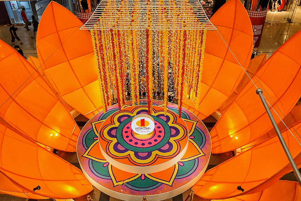 Huge orange petal flowers enveloping the kolam artwork in One Utama. — Picture by Ahmad Zamzahuri