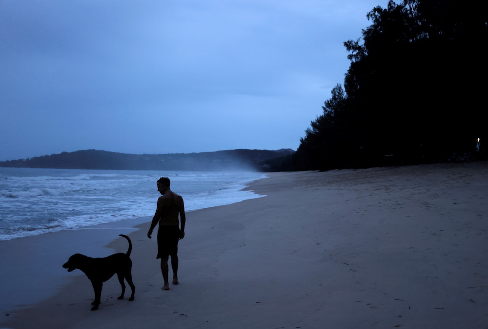 A man with his dog jogs in an empty beach in Phuket, Thailand September 25, 2021. u00e2u20acu2022 Reuters picnn