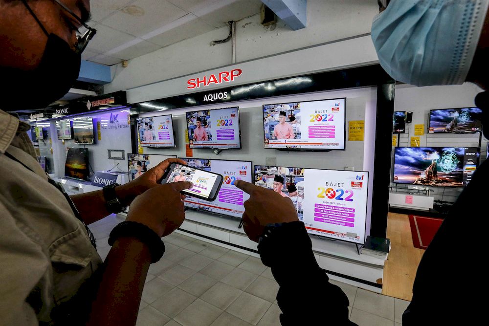 People watching the live presentation of the 2022 Budget by Finance Minister Tengku Datuk Seri Zafrul Tengku Abdul Aziz at Parliament, in Penang on October 29, 2021. u00e2u20acu201d Pic by Sayuti Zainudin