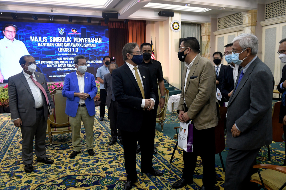 Sarawak Chief Minister Datuk Patinggi Abang Johari Openg speaks to an attendee of the symbolic handing-out of the BKKS 7.0 Plus at Wisma Bapa Malaysia in Kuching, October 14, 2021. u00e2u20acu201d Bernama picn