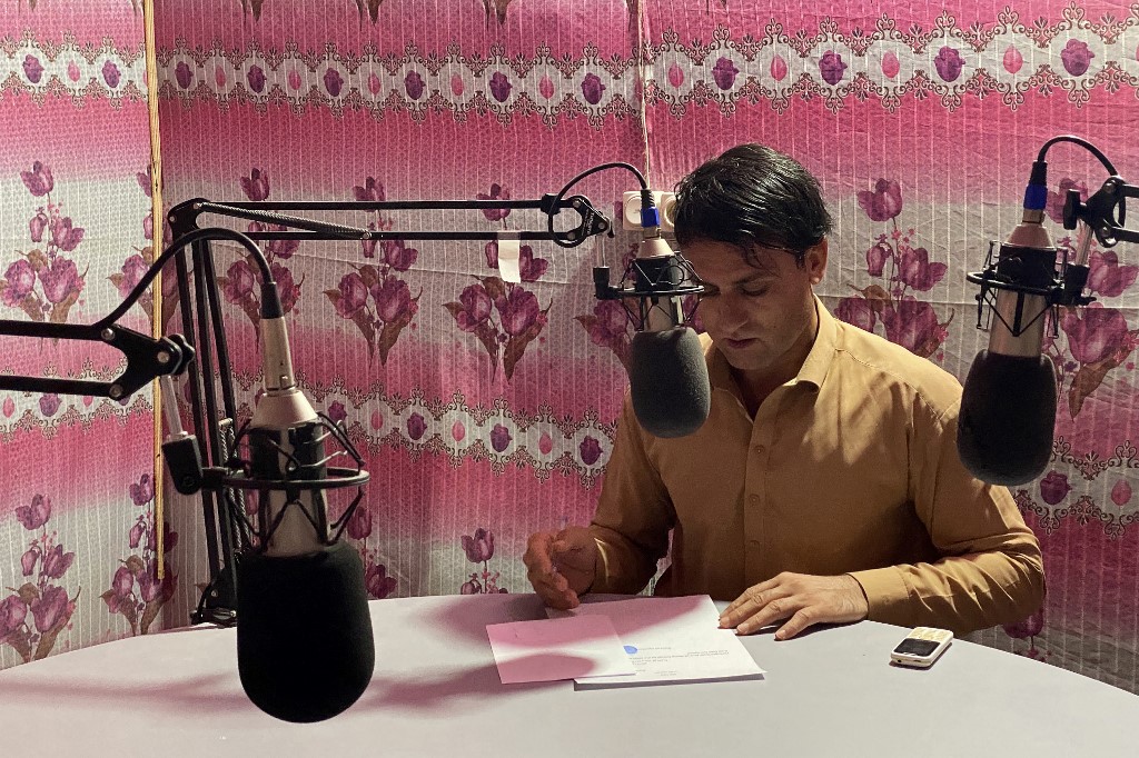 In this photograph taken on October 12, 2021, radio presenter Ebrahim Parhar reads the news during a broadcast at radio station Urooj in Farah province. u00e2u20acu201d AFP pic