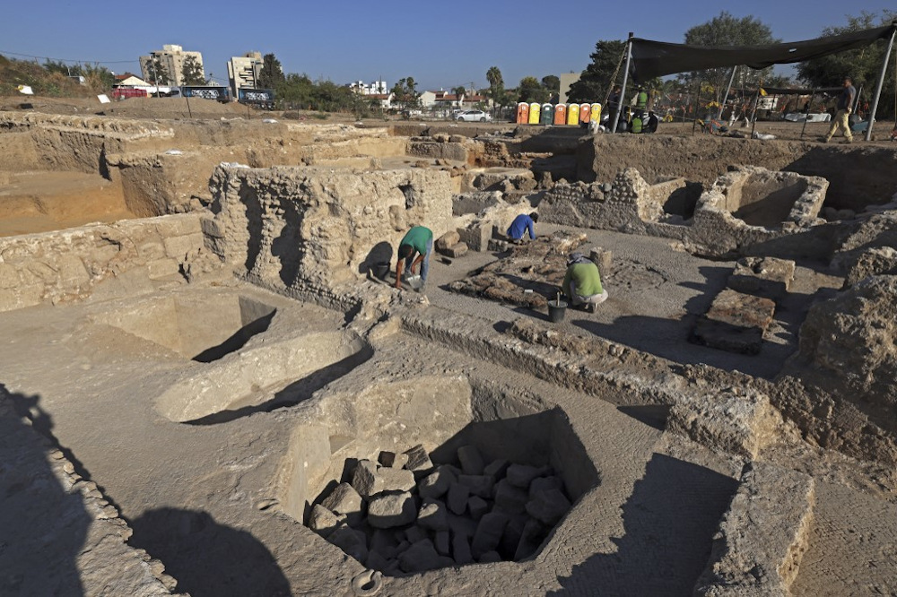 Archaeologists and technicians of the Israel Antiquities Authority excavate inside a winepress at the Tel Yavne site in central Israel on October 11, 2021, where a massive wine production facility was discovered. u00e2u20acu201d AFP pic