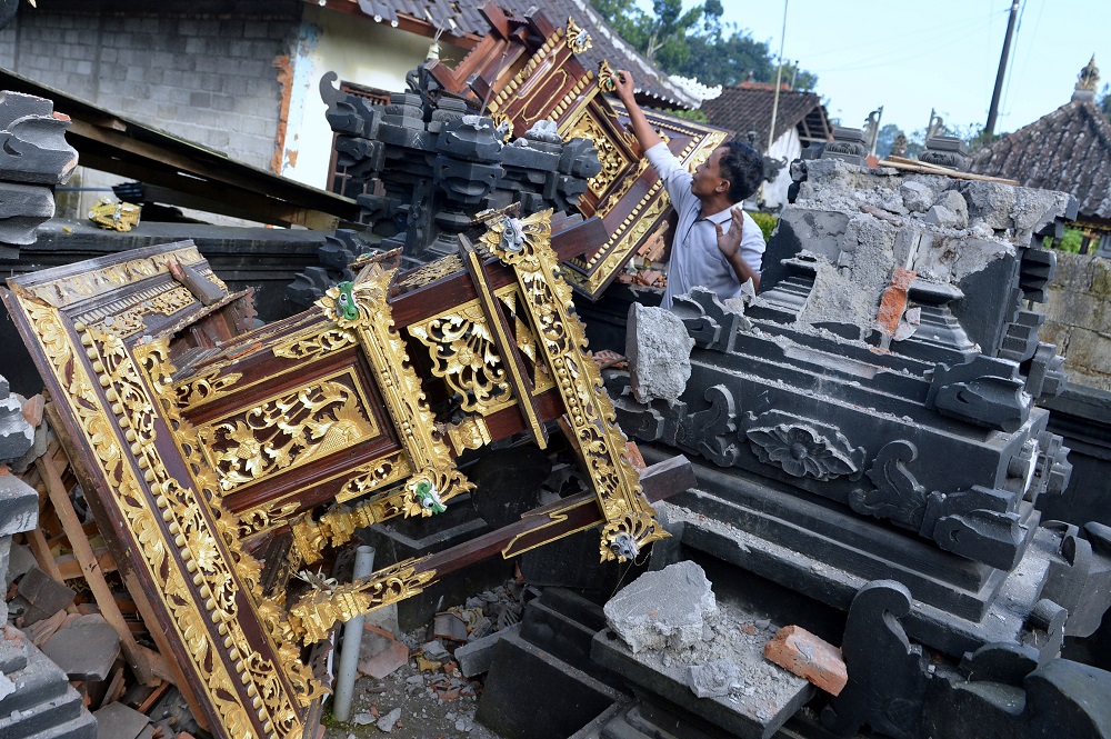 A man is seen among damaged buildings of a temple after a 4.8 magnitude earthquake struck northeast of Bali, in Karangasem, Bali, Indonesia October 16, 2021. u00e2u20acu2022 Antara Foto/Fikri Yusuf/via Reuters