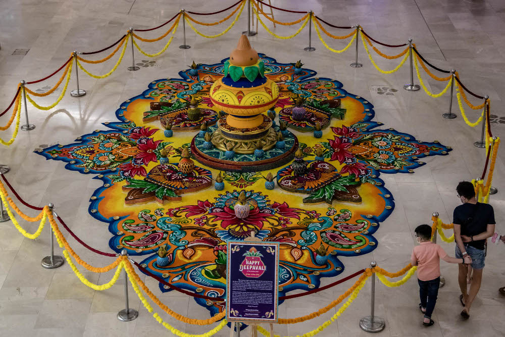 Shoppers walk past an Indian traditional creative artwork ‘Kolam’, a form of sandpainting, for the upcoming Deepavali festival celebration at The Gardens Mall in Kuala Lumpur, October 26, 2021. — Picture by Firdaus Latif