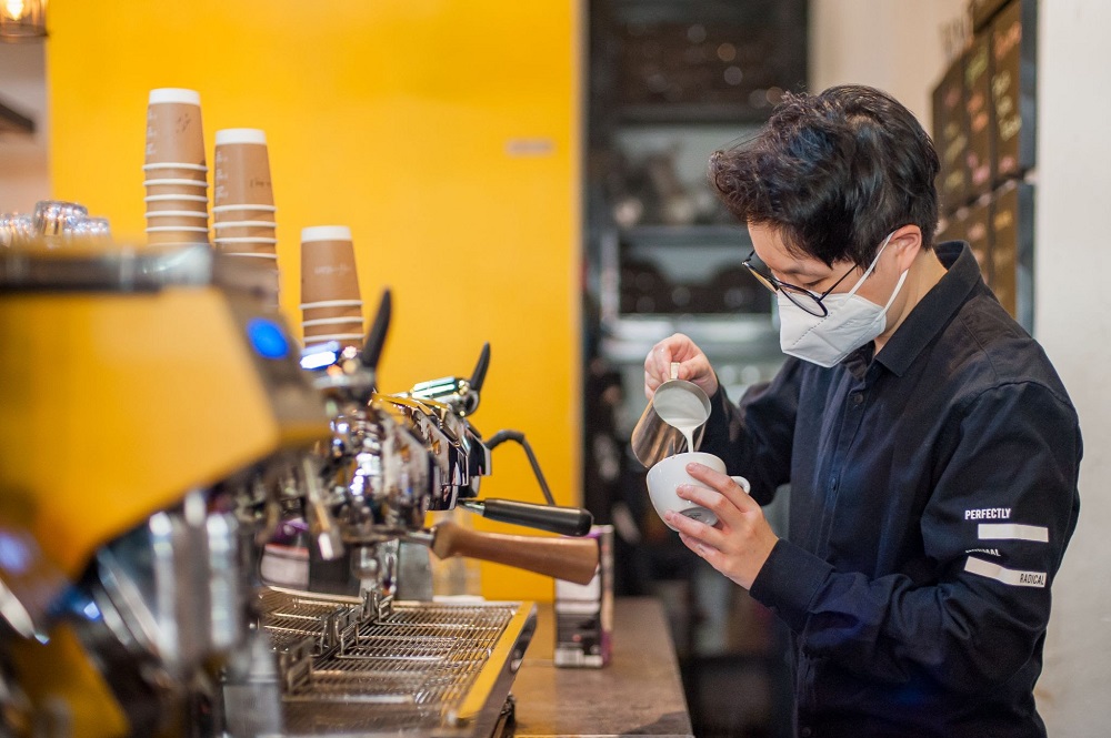 A barista at Coffee Stain meticulously making coffee. ― Picture courtesy of Grab