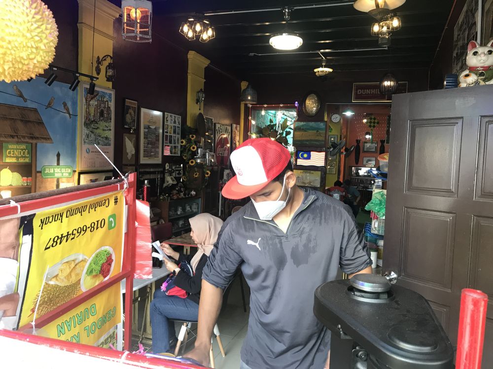 Wawasan Cendol Abang Kacak owner Kelvin Raj prepares cendol for customers. — Picture by Farhan Najib