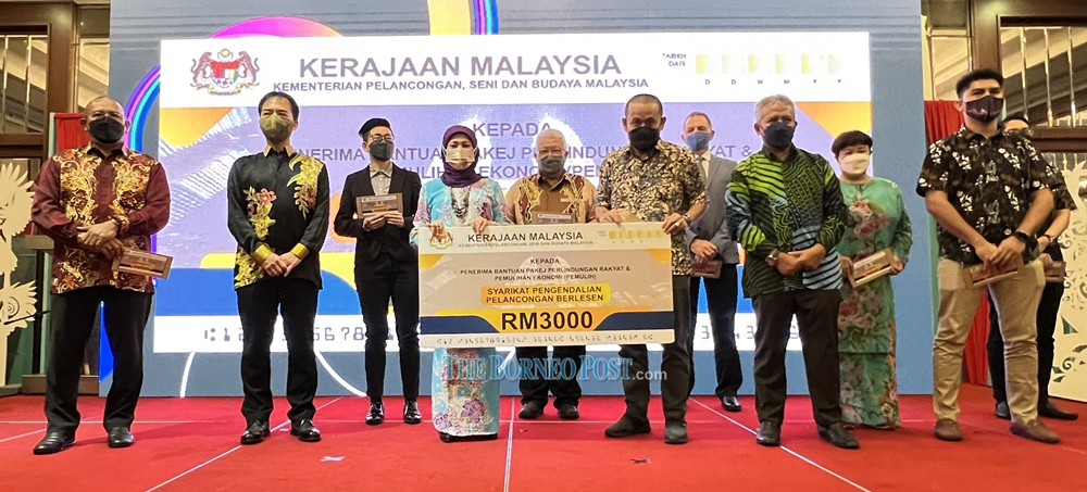 Nancy (fourth left) presents the financial assistance under u00e2u20acu02dcPakej Perlindungan Rakyat dan Pemulihan Ekonomi (Pemulih) to one of the recipients last night.  u00e2u20acu201d  Borneo Post Online pic