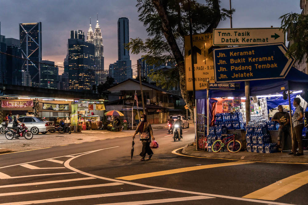 A woman wearing a mask walks during sunset in Kampung Datuk Keramat, Kuala Lumpur, October 28, 2021. u00e2u20acu201d Picture by Firdaus Latif