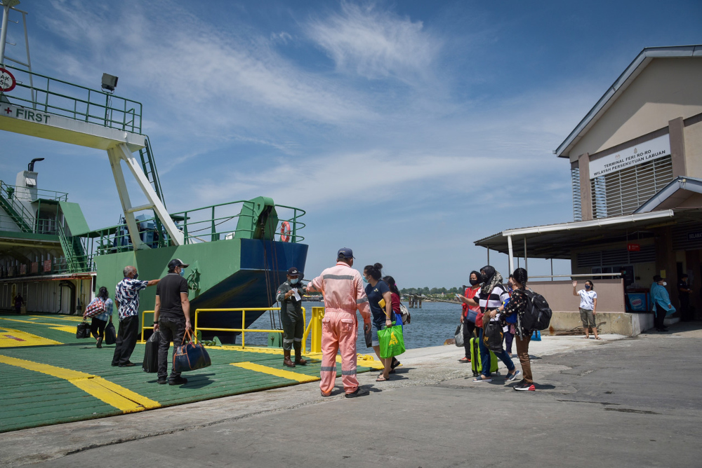 Travellers board the ro-ro ferry departing for Menumbok, Sabah at the main exit and entry gate at the Labuan International Ferry Terminal, October 13, 2021. u00e2u20acu201d Bernama pic 