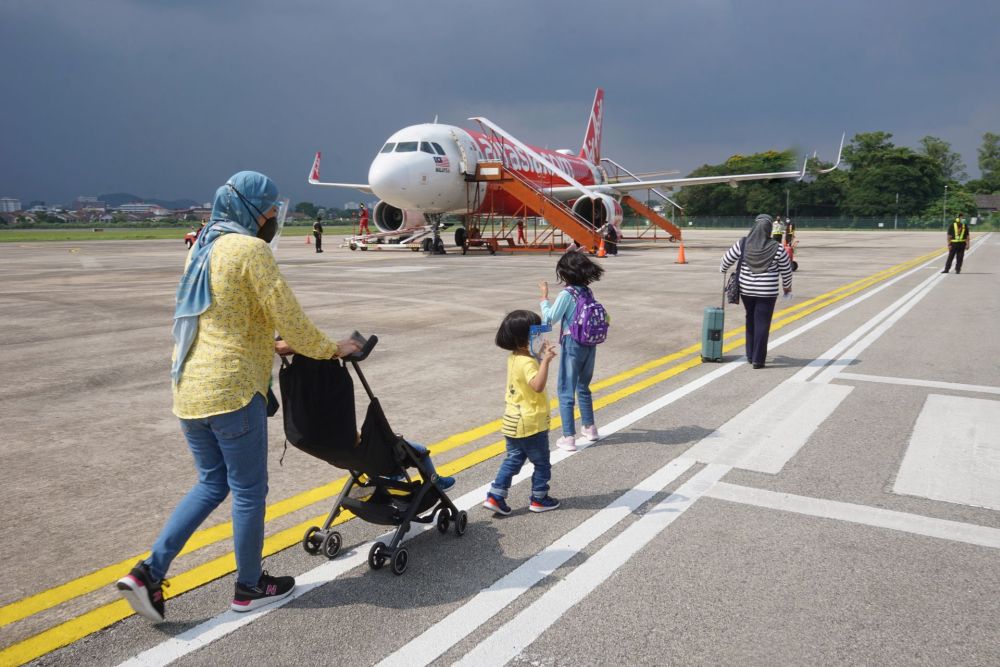 Tourists board an AirAsia flight headed to Langkawi at the Sultan Azlan Shah Airport in Ipoh October 3, 2021. u00e2u20acu201d Picture by Ahmad Zamzahuri