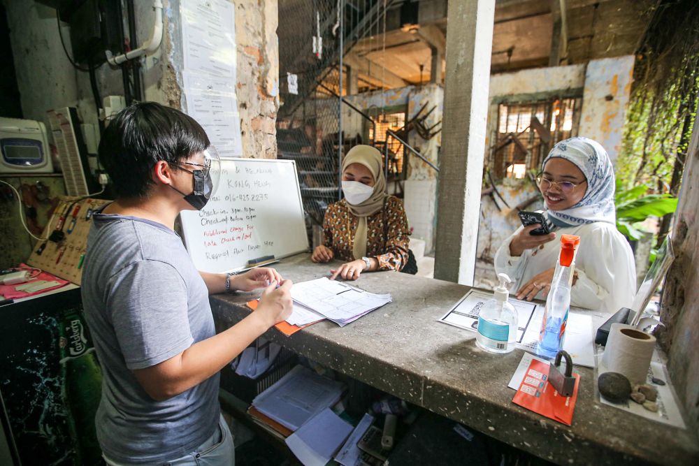 Tourists make enquiries at Sekeping Kong Heng by Dreamscape near Concubine Lane in Ipoh Ocotber 14, 2021. — Picture by Farhan Najib