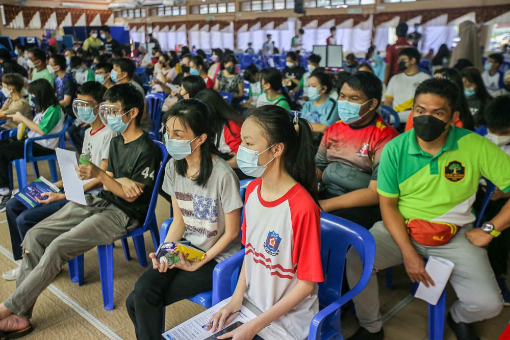 Students wait to receive their Covid-19 jab at SMA Izzuddin Shah in Ipoh October 5, 2021. u00e2u20acu201d Picture by Farhan Najib