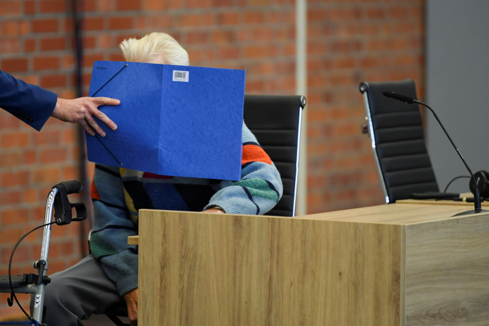 A 100-year-old former security guard of the Sachsenhausen concentration camp has his face covered by his lawyer, Stefan Waterkamp, as he appears in the courtroom before his trial in Brandenburg October 7, 2021. u00e2u20acu201d Reuters pic