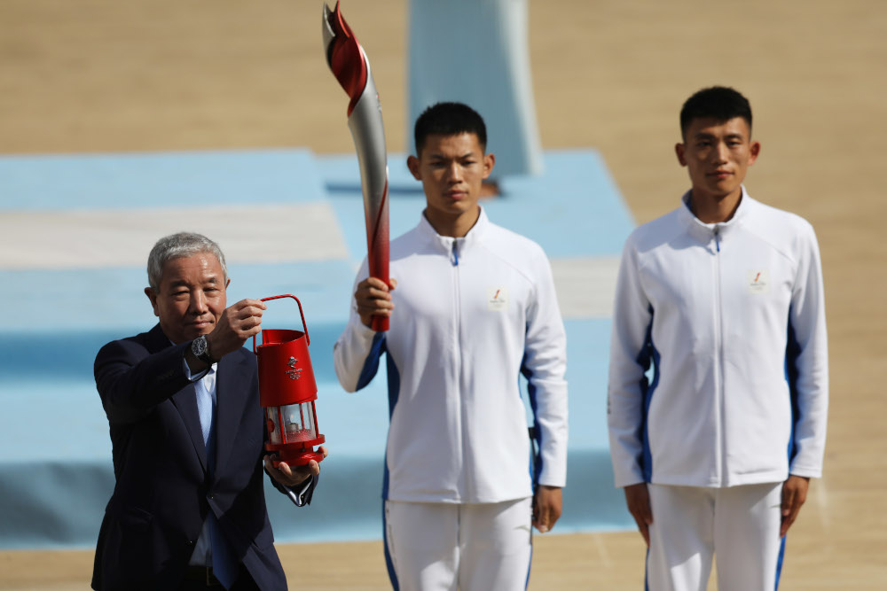 IOC vice-president and Organising Committee of Beijing 2022 Winter Olympics and Paralympics vice-president Yu Zaiqing poses with the flame during the handover ceremony in Athens October 19, 2021. u00e2u20acu201d Reuters pic