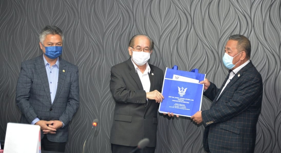 Deputy Chief Minister Datuk Amar Douglas Uggah (centre) hands over some cheques for Tarat constituency represented by assemblyman Datuk Roland Sagah Wee Inn (right). u00e2u20acu2022 Borneo Post pic
