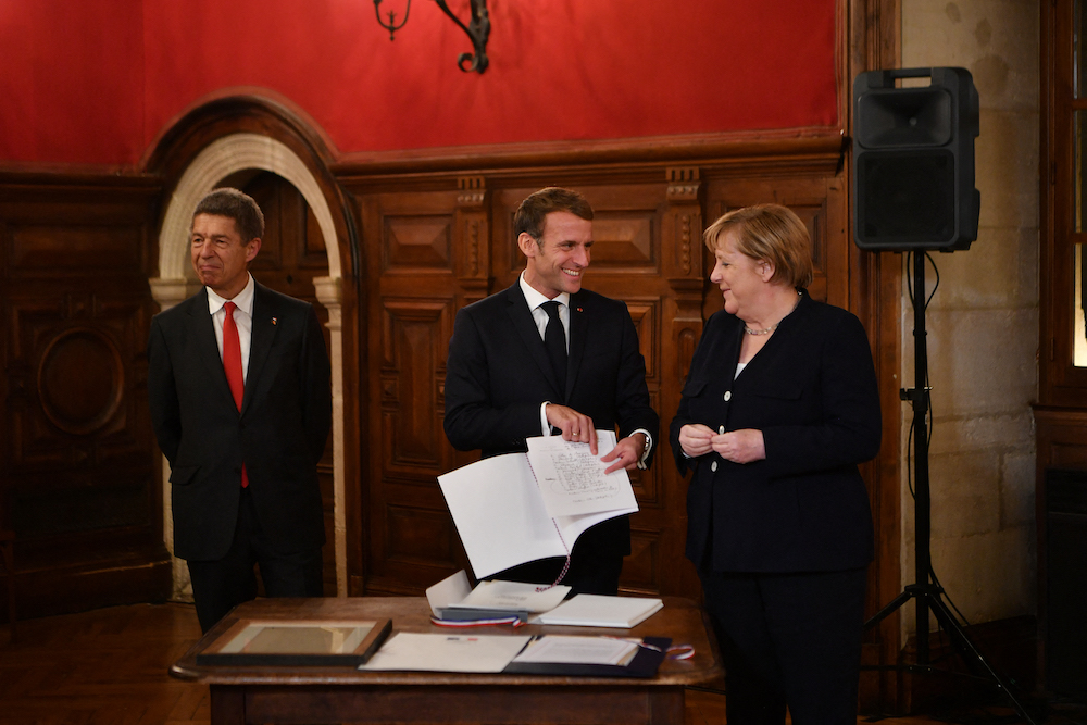 France's President Emmanuel Macron congratulates outgoing German Chancellor Angela Merkel during the ceremony of the Grand Cross, the highest distinction of the Legion d'Honneur, in Beaune November 3, 2021. u00e2u20acu201d AFP pic