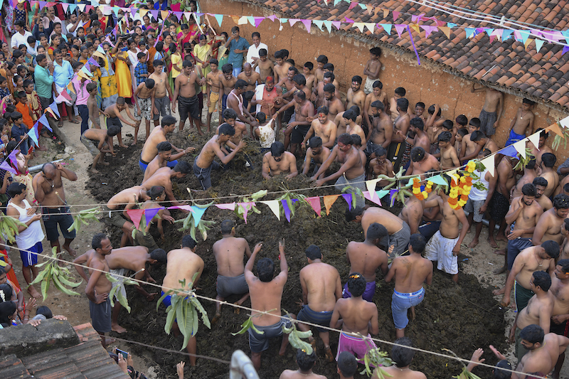 People watch as men fling cow dung at each other during the annual 'Gore Habba' festival, where people throw and smear each other with cow dung, in Gumatapura village November 6, 2021. u00e2u20acu201d AFP pic