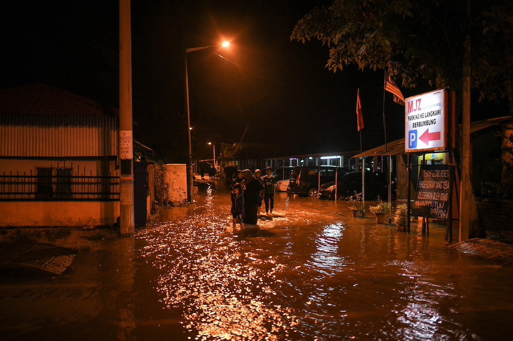 Some residents from Jalan Kuala Kedah are evacuated after their houses were inundated following the high tide phenomenon. u00e2u20acu201d Bernama pic