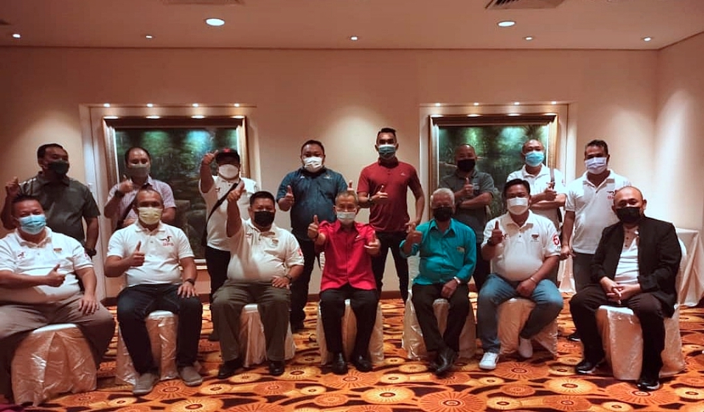 Talib (seated centre) poses for the camera with PBB Jepak Youth members. u00e2u20acu201d Borneo Post pic