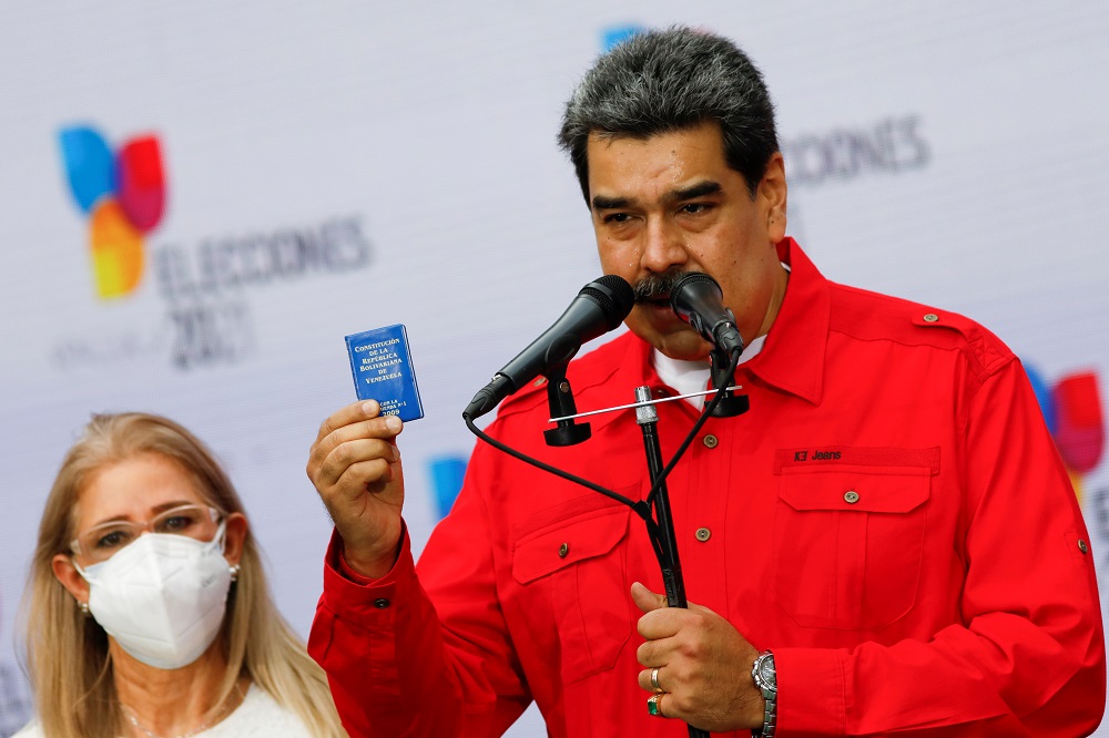 Venezuelau00e2u20acu2122s President Nicolas Maduro holds a small Venezuelan Constitution as he delivers remarks next to his wife Cilia Flores, after casting his vote during the election for state governors and local mayors, in Caracas November 21, 2021. u00e2u20acu201d Reuters p