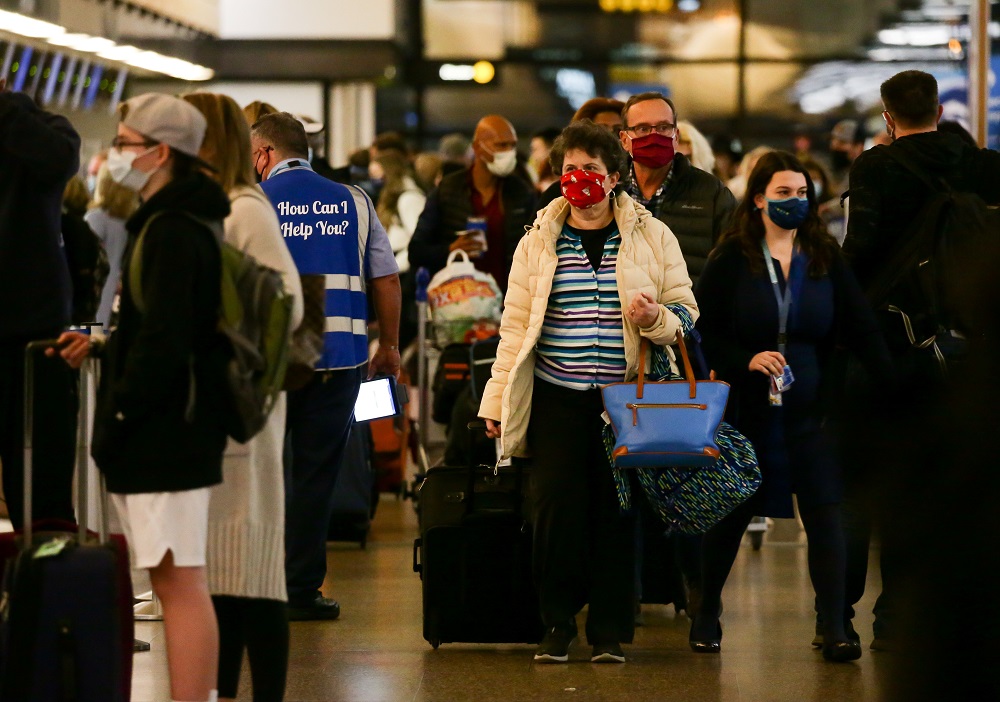 A traveller carries bags as people arrive at the ticketing level at Seattle-Tacoma International Airport before the Thanksgiving holiday in Seattle November 24, 2021. u00e2u20acu201d Reuters pic