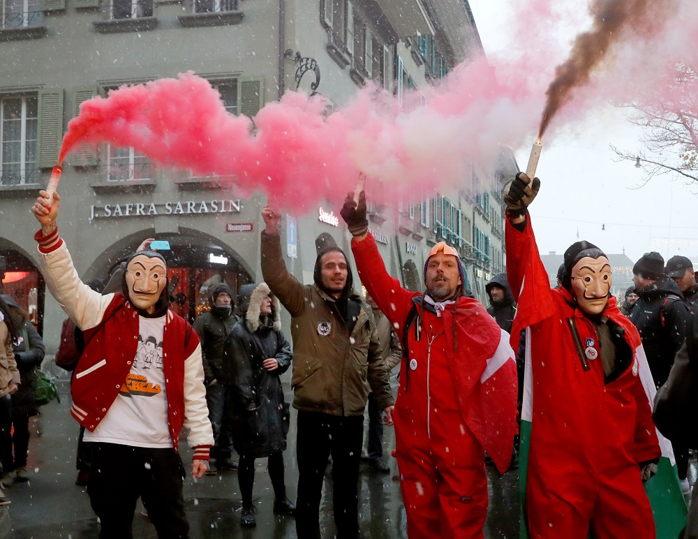 Demonstrators hold up flares during a protest against a coronavirus disease law that is voted on in a referendum, near the Swiss Federal Palace, the Bundeshaus, in Bern, Switzerland November 28, 2021. u00e2u20acu201d Reuters pic