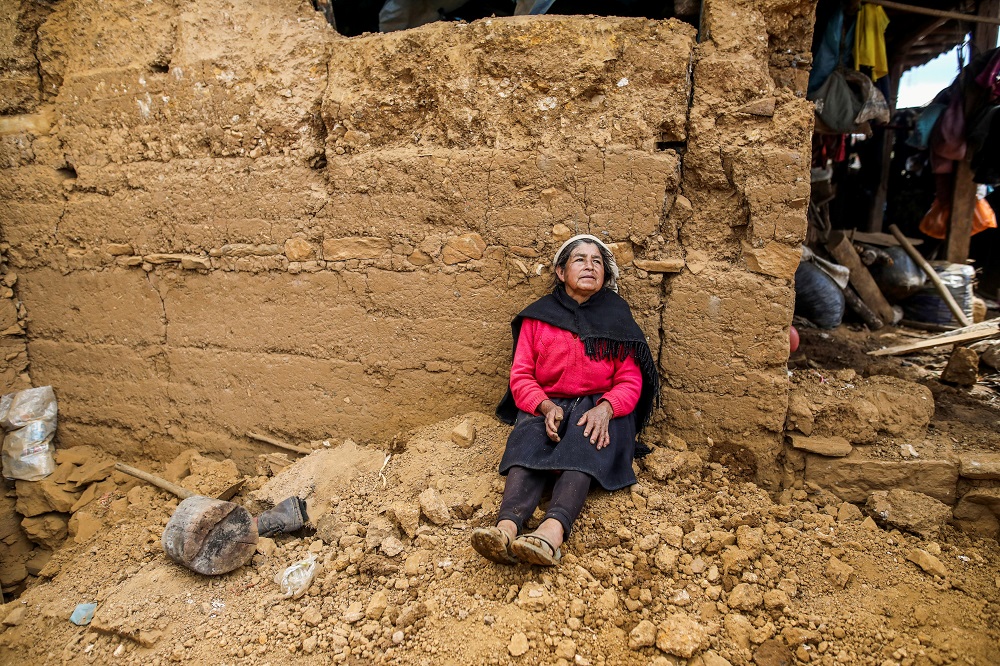 A woman rests outside a home affected by a quake in Jalca Grande, in the Amazonas region, Peru November 28, 2021. u00e2u20acu201d Peruu00e2u20acu2122s Presidency/Handout via Reuters