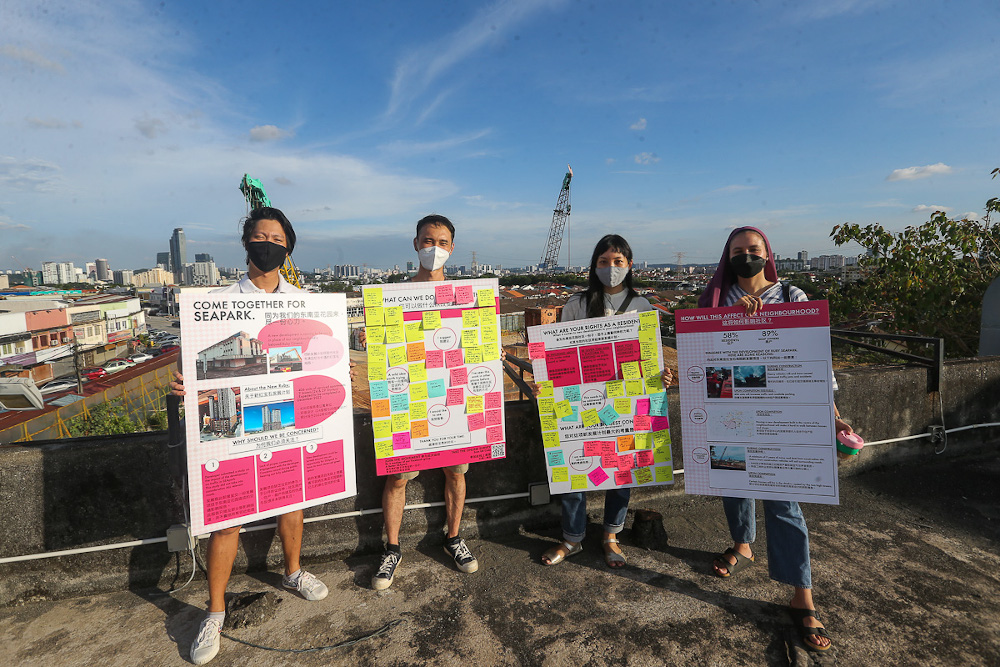 Yasmin Lane, Adeline Chua and Wong JT from A Better Sea Park together with a supporter at the construction site. — Picture by Yusof Mat Isa